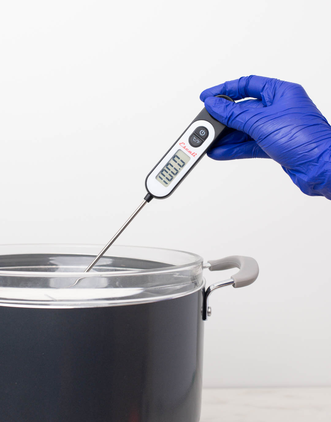Pouring mixture into diffuser bottle using a silver funnel.